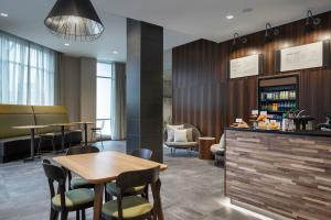 a restaurant with a table and chairs and a bar at Courtyard by Marriott Nanaimo in Nanaimo