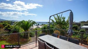 einen Balkon mit einem Tisch und einem Sonnenschirm in der Unterkunft Bermagui jewel holiday house 5 Bedroom Uninterrupted views central location Bermagui Linen & Wifi Provided in Bermagui