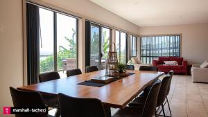 ein Esszimmer mit einem großen Holztisch und Stühlen in der Unterkunft Bermagui jewel holiday house 5 Bedroom Uninterrupted views central location Bermagui Linen & Wifi Provided in Bermagui