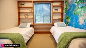 zwei Betten in einem Zimmer mit einer Landkarte an der Wand in der Unterkunft Bermagui jewel holiday house 5 Bedroom Uninterrupted views central location Bermagui Linen & Wifi Provided in Bermagui