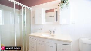 ein Badezimmer mit Waschbecken und Dusche in der Unterkunft Bermagui jewel holiday house 5 Bedroom Uninterrupted views central location Bermagui Linen & Wifi Provided in Bermagui + 22 Fotos
