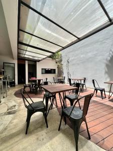 Un grupo de mesas y sillas en un patio. en Aruma Suites, en Playa del Carmen 11 fotos más