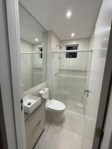 een badkamer met toilet en glazen douche bij Novinho em Camboriú in Balneário Camboriú