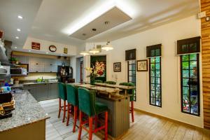 a kitchen with a large island with green bar stools at REGINA HOME in San Salvador de Jujuy