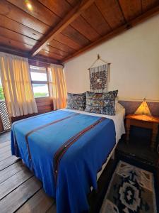 a bedroom with a blue bed in a room at Yellow House Hostel B&B in Antigua Guatemala