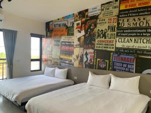 two beds in a room with posters on the wall at 水玥椰林民宿 in Yuanshan