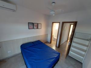 ein Schlafzimmer mit einem blauen Bett und einer Treppe in der Unterkunft Sobrado frente ao SESC, WIFI 300MB, 2 vagas auto, cozinha, churrasqueira, moderno e reformado in Bertioga