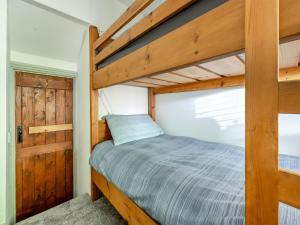 1 dormitorio con litera de madera y puerta en Lakeview Cottage - Uk44099 en Carsington