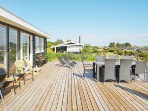 una terraza de madera con mesa y sillas. en Holiday home Slagelse XXXVIII, en Slagelse