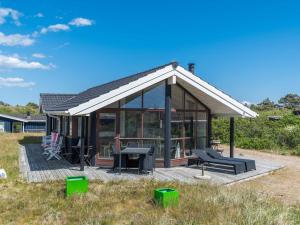 a small house with a deck and a table at Holiday home Fanø VII in Fanø