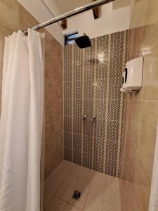 a shower with a shower curtain in a bathroom at Yellow House Hostel B&B in Antigua Guatemala