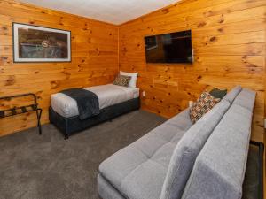 a room with a couch and a bed and a tv at Tasman Holiday Parks - Rotorua in Rotorua