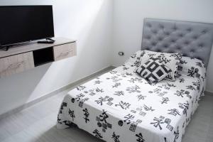 - une chambre avec un lit et une télévision dans l'établissement Apartahotel 222 Apartamento 304, à Pereira