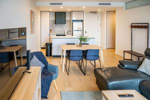 a living room and kitchen with a table and a couch at 2 BR family business friendly CBD ANU in Canberra