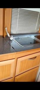 - un comptoir de cuisine avec un évier et un ventilateur dans l'établissement Hotel caravana Guadalupe, à Tarragone
