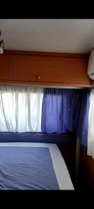 a small bedroom with a bed and a window at Hotel caravana Guadalupe in Tarragona