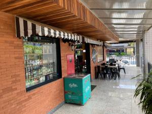 a building with a soda shop with a table in it at Flats Asa Norte CLN 213 by CentoEdez in Brasilia