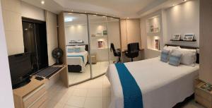 1 dormitorio con 1 cama grande y TV en Flats Asa Norte CLN 213 by CentoEdez, en Brasilia