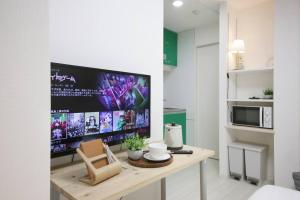 een keuken met een tafel en een tv in een kamer bij Real Kinshi 201 in Tokyo