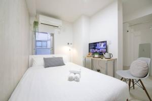 een witte slaapkamer met een wit bed en een stoel bij Real Kinshi 201 in Tokyo