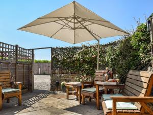 a patio with a table and an umbrella at Chapel House in Bourton on the Water