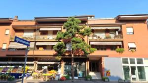 un immeuble d'appartements avec un arbre en face de celui-ci dans l'établissement Residenza Fiera Verona in, à Vérone