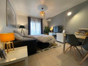 um quarto com uma cama e uma secretária com uma secretária. em ToulonHost - Le Litardi - Superbe T2 - 2 pas des plages - Clim - Fibre em Toulon