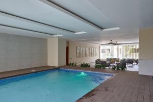 - une piscine dans une maison avec un salon dans l'établissement Apartamento con piscina y parqueo, encanto urbano, à Ciudad Nueva