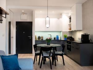 eine Küche mit einem Tisch und Stühlen im Zimmer in der Unterkunft A comfortable apartment very close to the seaside beach, Niechorze in Niechorze
