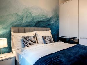 a bedroom with a bed with a painting on the wall at A comfortable apartment very close to the seaside beach, Niechorze in Niechorze