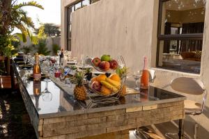 a long table with fruit in a basket on it at Milele Lodge in Gaborone