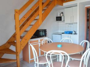 uma cozinha com uma mesa e cadeiras e uma escadaria em Maison Narbonne, 3 pièces, 5 personnes - FR-1-229B-94 em Narbona
