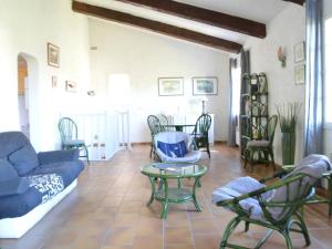 uma sala de estar com um sofá azul e cadeiras em Maison Cavalaire-sur-Mer, 6 pièces, 10 personnes - FR-1-226B-158 em Cavalaire-sur-Mer