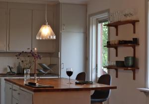 a kitchen with a table with a glass of wine at Villa with mountain view in the Swedish High Coast in Docksta