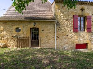 uma velha casa de pedra com persianas vermelhas e uma porta em Gîte Montferrand-du-Périgord, 2 pièces, 4 personnes - FR-1-616-328 em Montferrand-du-Périgord