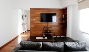 sala de estar con sofá y TV en la pared en Apartment 41 Melian en Buenos Aires