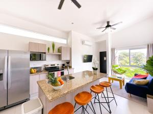 a kitchen with a counter and some stools at Pura Vida Apartment with nice pool walking distance to the heart of Jaco in Jacó