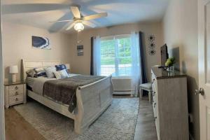 a bedroom with a bed and a ceiling fan at Bungalow near Winnisquam Lake! Sleeps 14 in Sanbornton