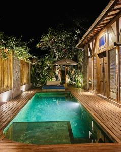 ein Pool auf einer Holzterrasse in der Nacht in der Unterkunft Samsara Villas in Gili Air