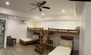Pokój z 2 łóżkami piętrowymi i wentylatorem sufitowym w obiekcie P&B Residences Legazpi w mieście Legazpi