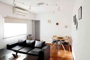 sala de estar con sofá negro y mesa en Apartment 41 Melian en Buenos Aires
