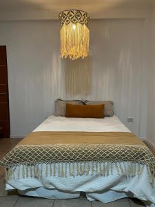 a bedroom with a bed with a chandelier at Departamento céntrico en Corrientes in Corrientes