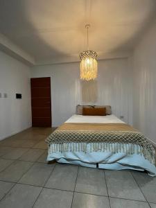 a bedroom with a large bed with a chandelier at Departamento céntrico en Corrientes in Corrientes