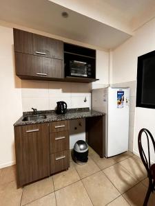 a kitchen with a white refrigerator and a microwave at Departamento céntrico en Corrientes in Corrientes