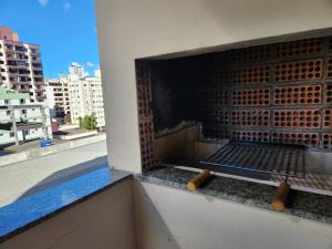 un balcón con una parrilla en el lateral de un edificio en 2 quartos a 200mts praia Central, GARAGEM, CHURRASQUEIRA, WI-FI 90 Mbps, PET FRIENDLY, en Balneário Camboriú