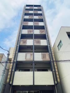 un grand bâtiment avec des fenêtres sur son côté dans l'établissement Apartment Hotel 11 Namba Minami Shin-Imamiya, à Osaka
