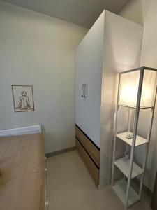 a white room with a shelf and a refrigerator at Luxe Staycation S Residences Tower 3 MOA in Manila