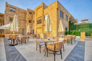 a patio with tables and chairs and umbrellas at The Gate Hotel Front Pyramids & Sphinx View in Cairo