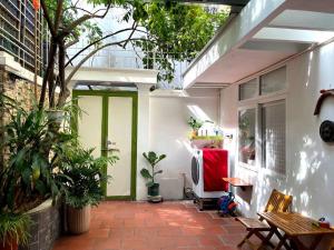 ハノイにあるPeaceful houseの鉢植えの植物と緑のドアが備わるパティオ