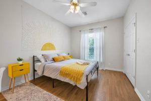um quarto com uma cama e uma ventoinha de tecto em Taste of Everything House 5 from Baylor & Magnolia em Waco